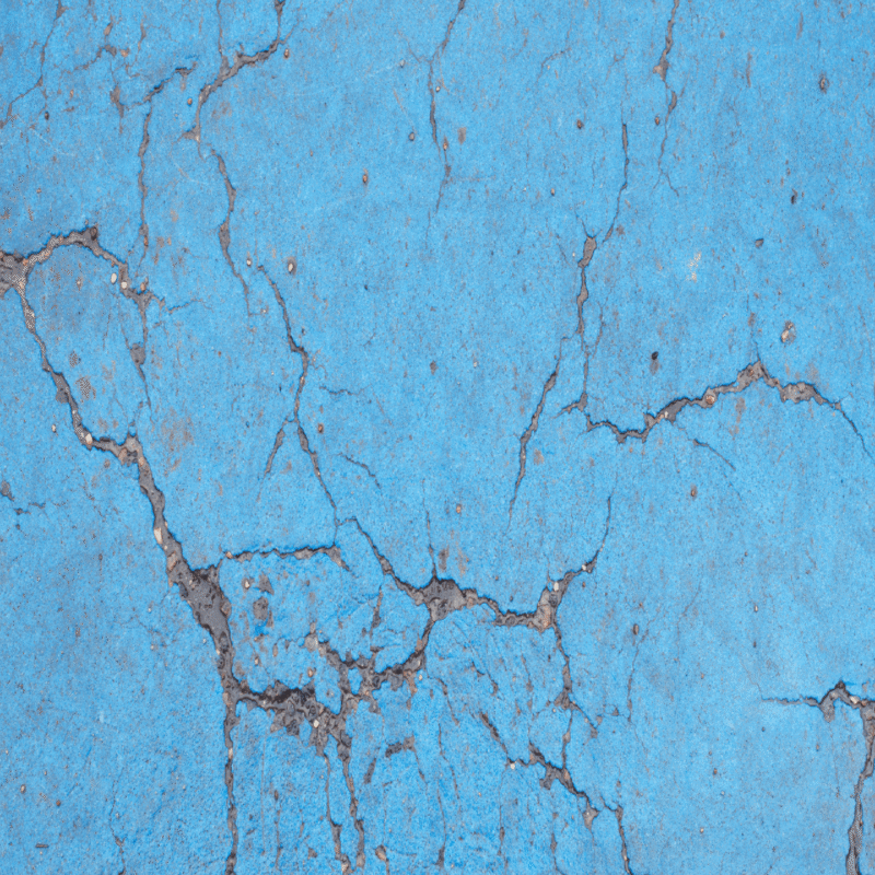 Blue Concrete wall with cracks all over it