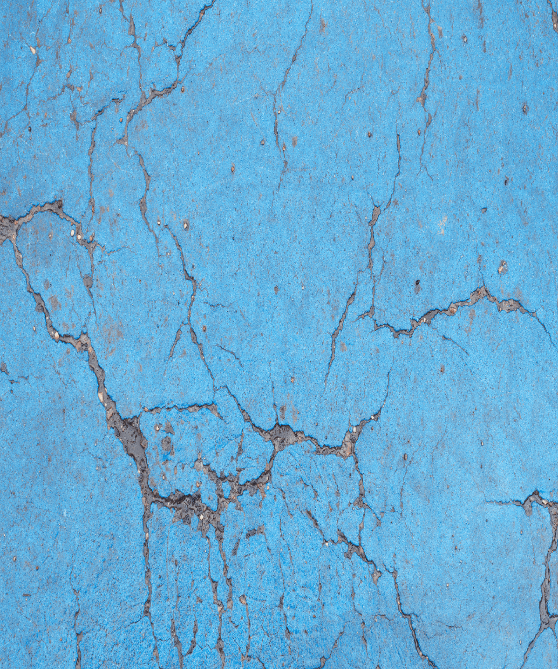 Blue Concrete wall with cracks all over it